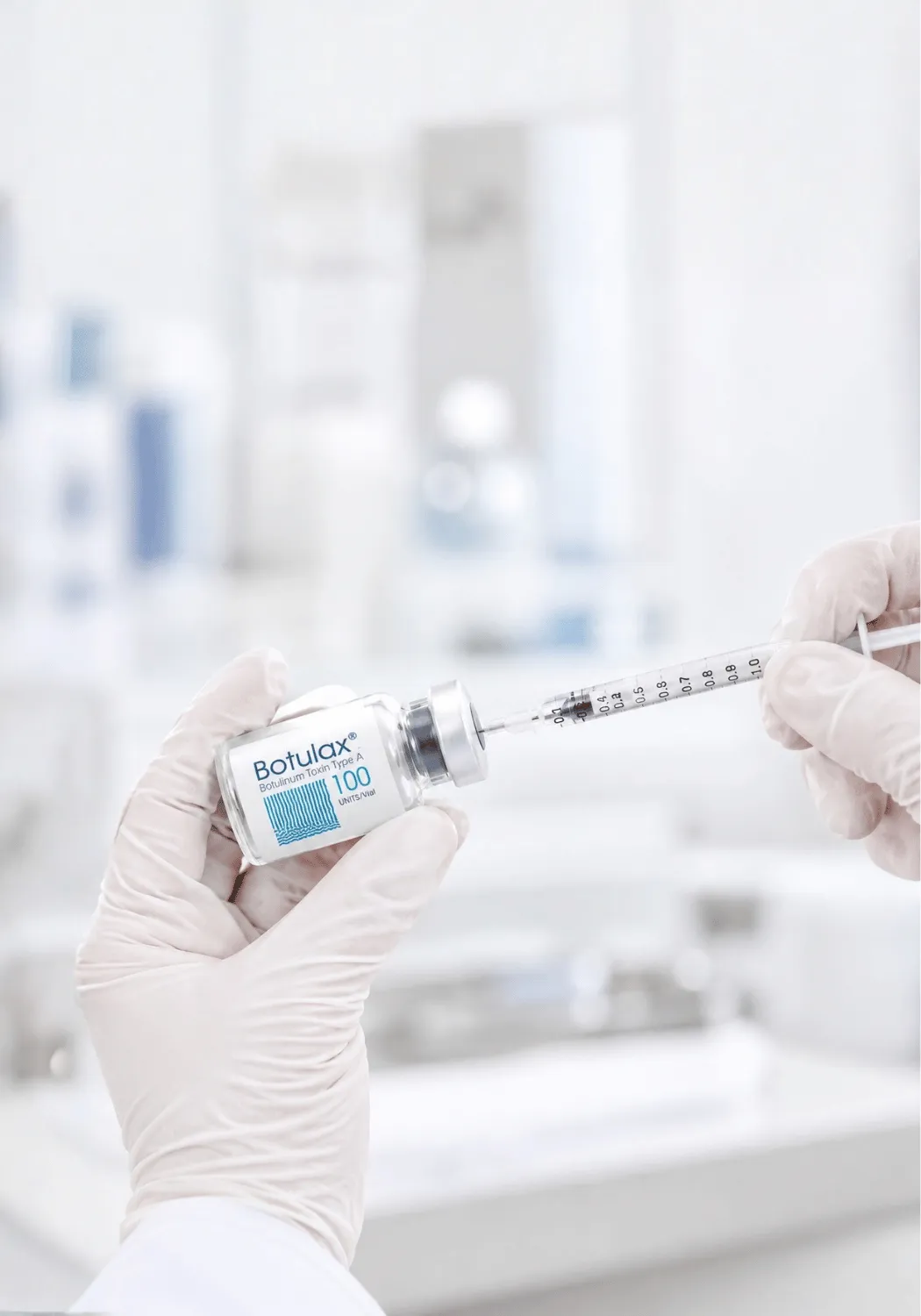 Gloved hands inserting a syringe into a Botulax 100 unit vial